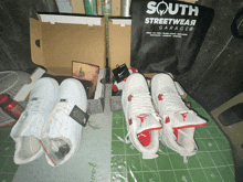 a pair of air jordan shoes are sitting on a table next to a south streetwear garage bag