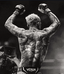 a black and white photo of a fighter wearing venum pants