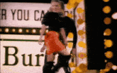 a woman in a red skirt is dancing in front of a burberry sign