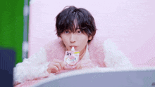 a man in a pink fur coat is drinking from a pink pouch