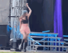 a woman in a pink dress is standing on a stage