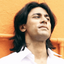 a close up of a man 's face with long hair