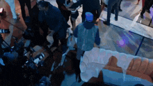 a group of people are gathered in a room with a couch in the foreground and a sign that says us news