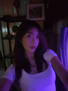 a woman in a white shirt is taking a selfie