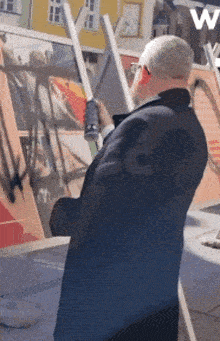 a man in a suit is spray painting a picture with a spray can