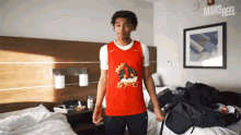 a man wearing a red shirt that says 5tg on it
