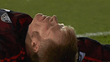a soccer player laying on the field with a shirt that says ' united ' on it