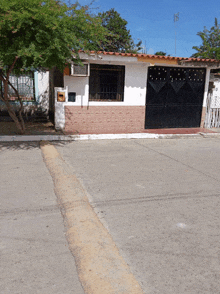 a small house with a black gate and a mailbox on the side of it