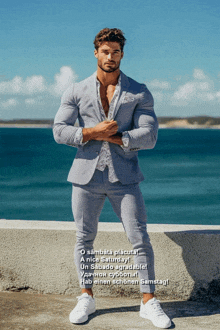 a man in a suit is standing in front of the ocean with the words o sambata placutai a nice saturday