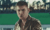 a man in a leather jacket is standing in front of a green screen .