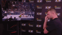 a man stands in front of a wall that says aew draft kings