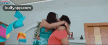 a man and woman are hugging each other in a room .