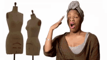a woman is standing in front of a mannequin with her mouth open and making a funny face .