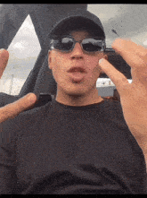 a man wearing sunglasses and a hat is making a funny face
