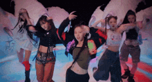 a group of young women are dancing in a room with a cloud in the background .