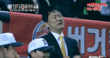 a man in a suit and tie is crying in front of a burg banner