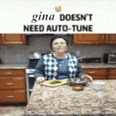 a woman in a kitchen with a sign that says gina doesn t need auto-tune