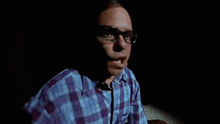 a man wearing glasses and a plaid shirt