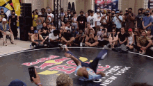 a man is doing a trick on a mat that says " red bull " on it
