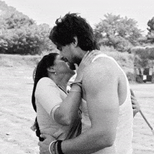 a black and white photo of a man and a woman kissing