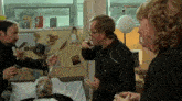 a group of people are standing around a man in a hospital bed with an oxygen mask on his face