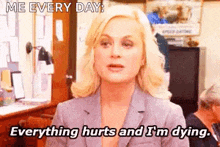 a woman in a suit is saying everything hurts and i 'm dying