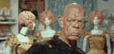 a man with a brain on his head stands in front of a group of mannequins