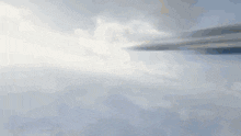 a jet is flying through a cloudy sky with a rocket coming out of it
