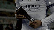 a person wearing a shirt that says " getsson sport "