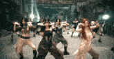 a group of women are dancing in a room with rocks in the background