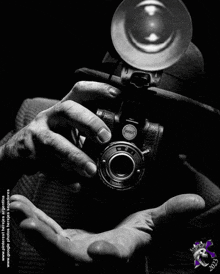 a black and white photo of a person holding a camera that says ' bosch ' on the lens