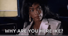 a woman is sitting in the back seat of a car and asking why are you here ike ?