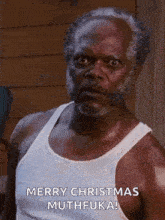 a man with a beard and mustache is wearing a white tank top and says merry christmas muthfuka .