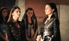 a woman in a black dress stands next to a woman in a silver dress
