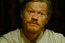 a close up of a man 's face with a red spot on his lip