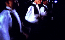 a group of men are standing in a dark room with a flashlight