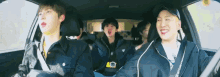 a group of young men are sitting in a car laughing and singing .