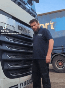 a man standing in front of a truck that says daf on it