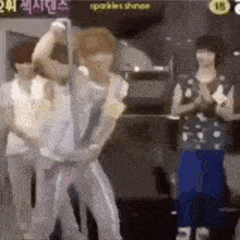 a group of people are standing in a room and dancing .