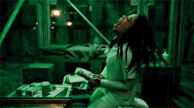 a woman is sitting on the floor in a room with her mouth open and holding a remote control .