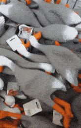 a bunch of stuffed animals including a goose with orange legs