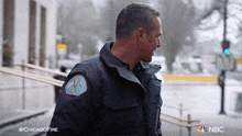 a man in a chicago fire jacket walking down a street