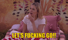 a woman is sitting on a couch with the words let 's fucking go