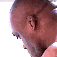 a close up of a bald man 's head with a beard looking down .