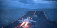 a fighter jet is taking off from the deck of a ship