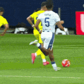 a soccer player wearing a white jersey with the number 5 on it
