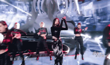 a group of people are dancing on a stage with chinese writing