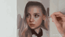a person is painting a woman 's face with a brush on a piece of paper .
