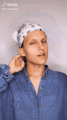 a man wearing a bandana and a denim shirt has a tiktok sticker on his shirt