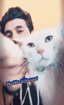 a man holding a white cat with the words muffin ki jhappi written on the bottom